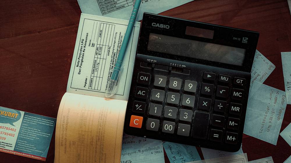 Modern workspace with legal paperwork and calculator representing settlement payout calculation