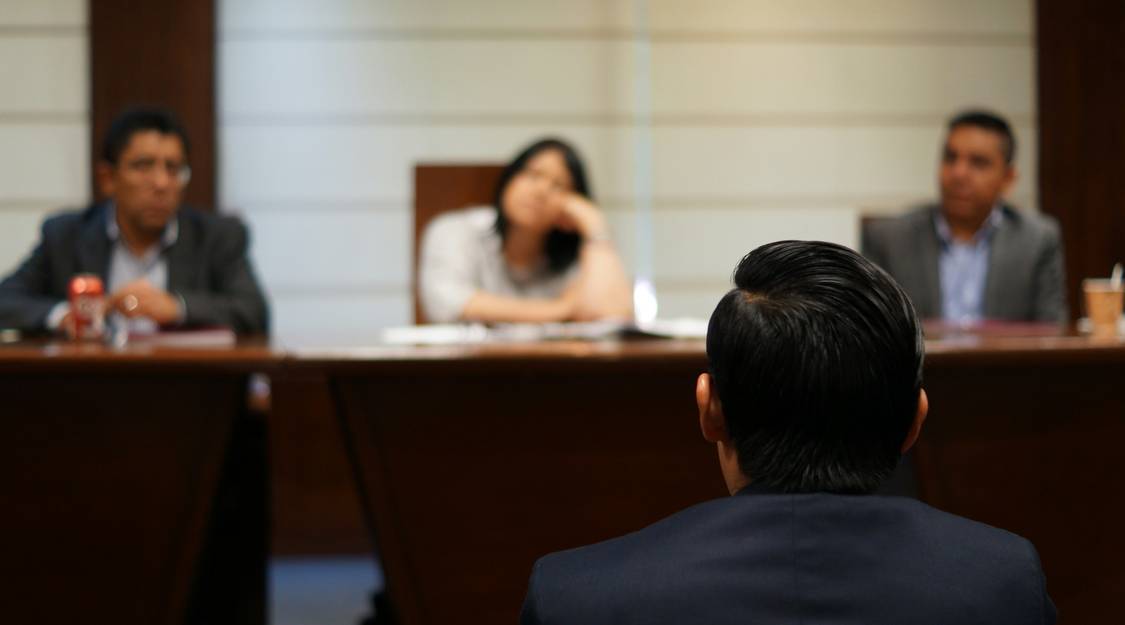 Attorney and injured worker discussing workers' comp settlement with documents on table